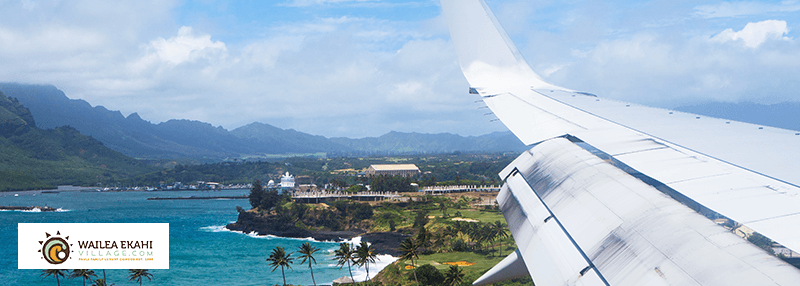 Plane wing and Hawaii beach and land landscape in background