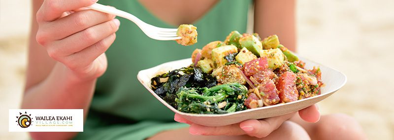 Woman holding plate of food and food on a fork