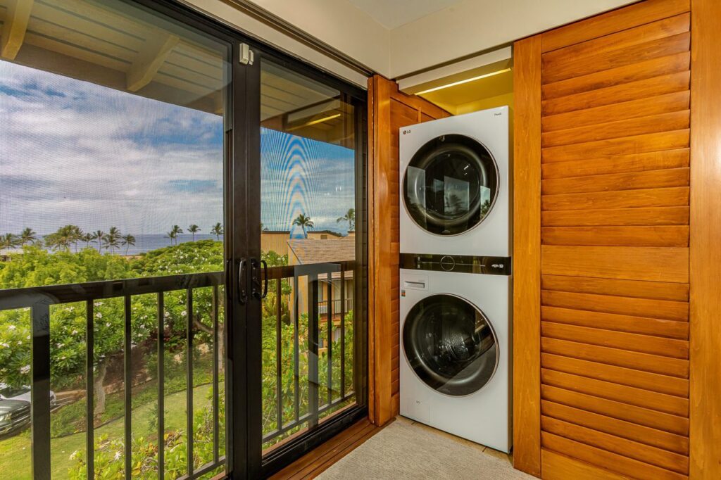 In unit laundry machines with balcony views next to them in Unit 11E