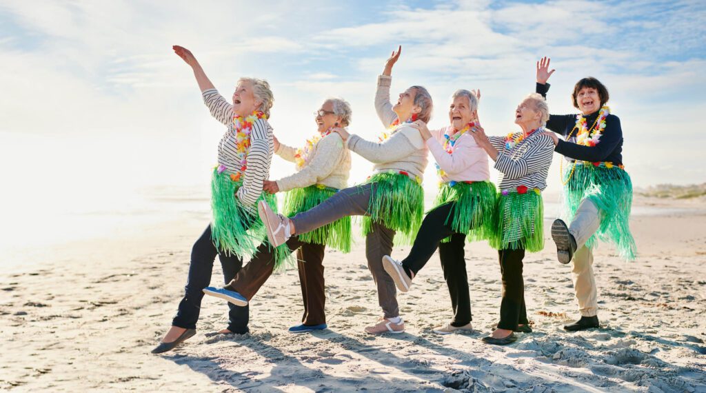 Group of happy older women hula dancing on the beach