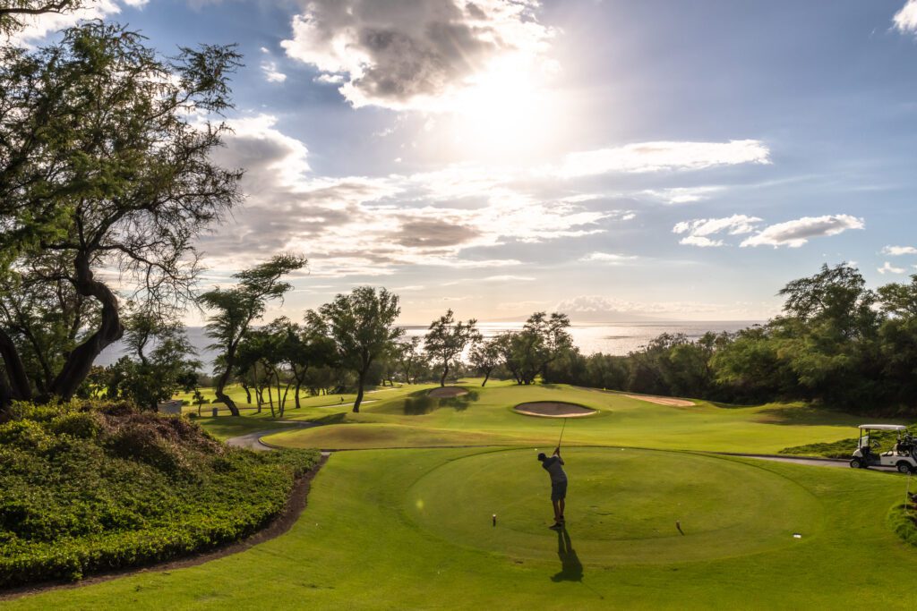 View of man swinging golf club on Wailea Emerald Golf Course in Wailea, Maui, Hawaii