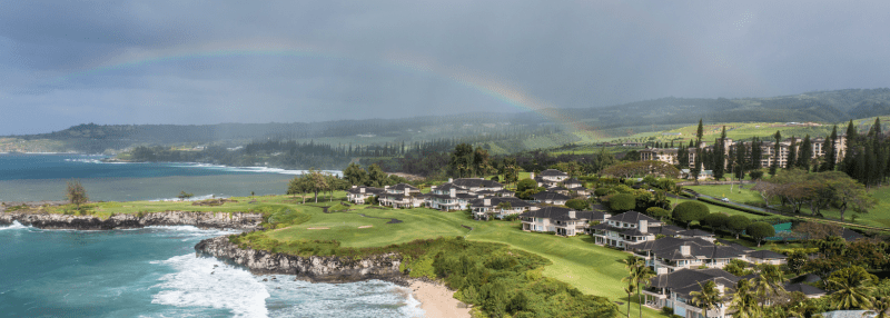 Rainy weather on Maui with residences in the background and a rainbow in the sky