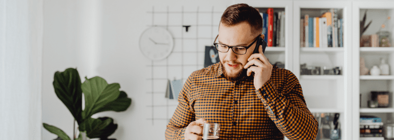 Man making a phone call while holding a drink