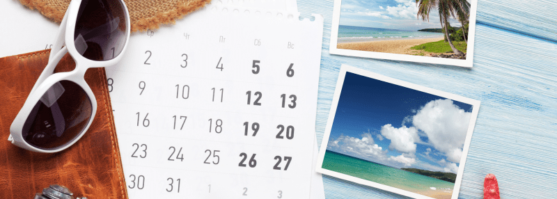 Calendar with photos of tropical destinations, sunglasses, and journal