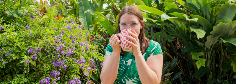 Woman enjoying her coffee and sipping it outside in Hawaii